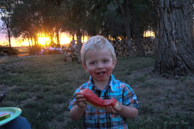 A little dirt and watermelon juice make for a happy boy.